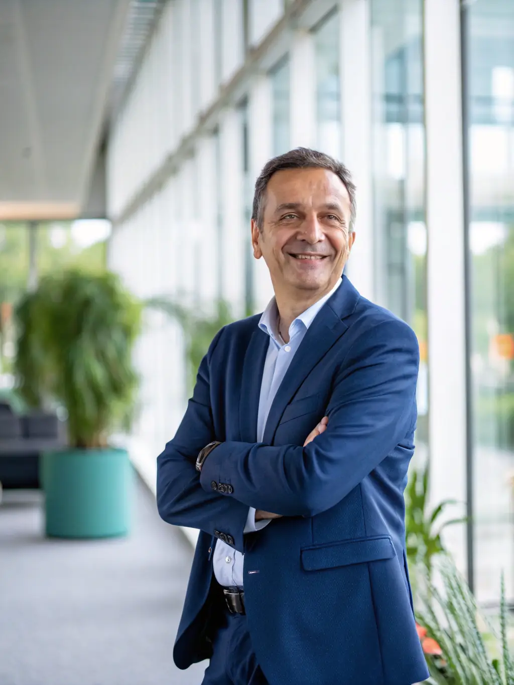 A professional headshot of a successful-looking, smiling halal investor in a modern office setting, conveying trustworthiness and financial acumen.